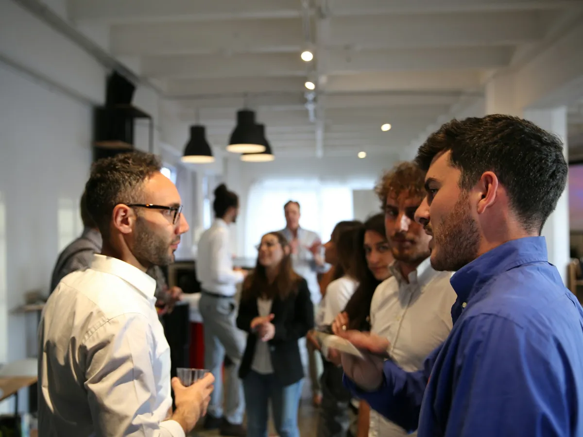 People talking in small groups at a networking event