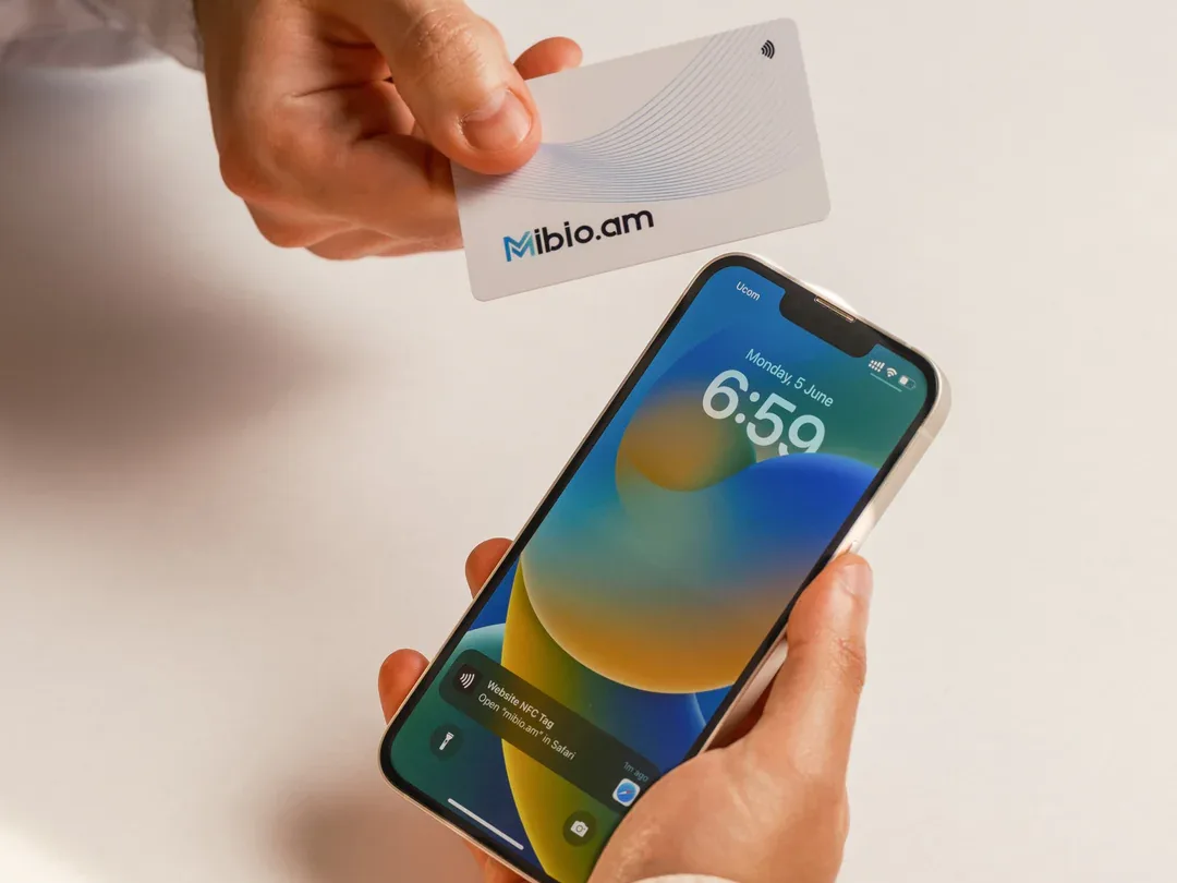 A white Mibio card held against an iPhone that shows the NFC notification